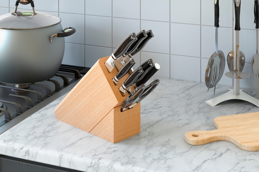 kitchen knife set and other utensils in background